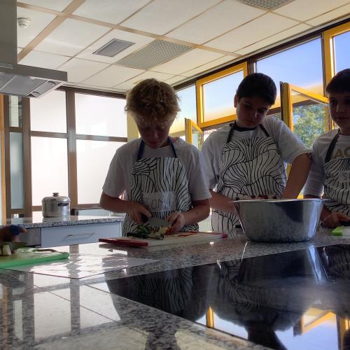 Drei Schüler schneiden Obst für den Obstsalat