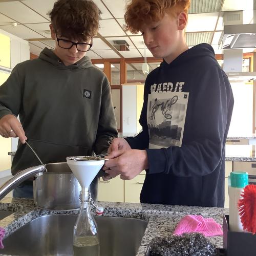 Zwei Schüler beim abfüllen von Sirup