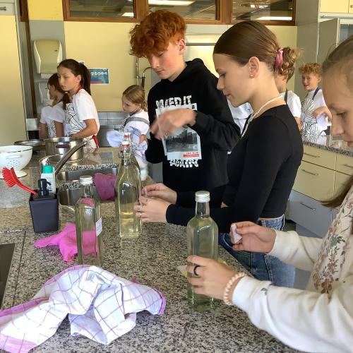 Schülerinnen und Schüler der 4. Klasse etikettieren die Sirupflaschen