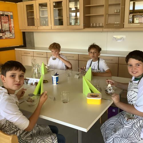 Vier Schüler beim Genießen des Obstsalates