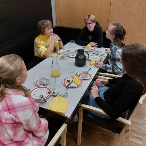Fünf Schülerinnen sitzen am Frühstückstisch