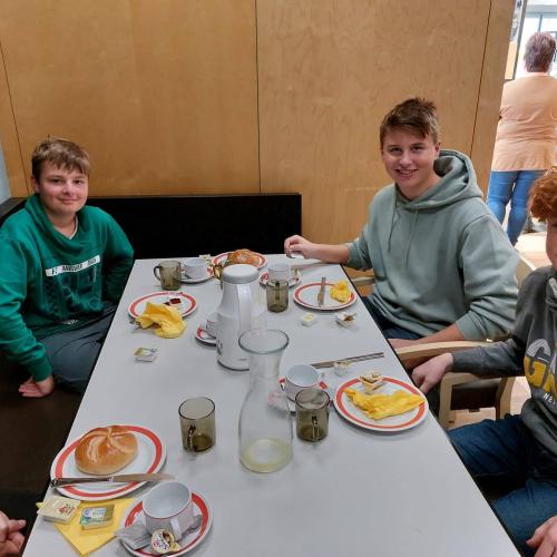 Drei Schüler am Frühstückstisch