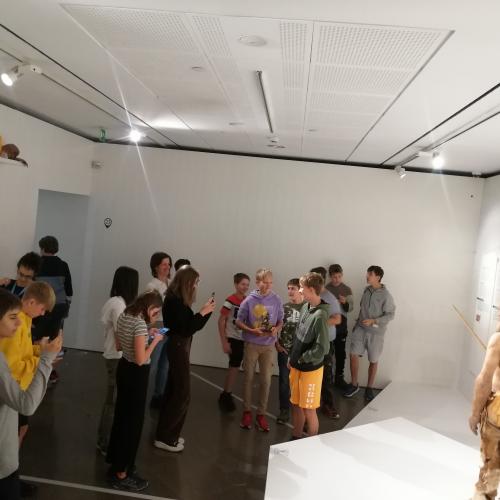 Schülerinnen und Schüler betrachten Ötzi im Museus