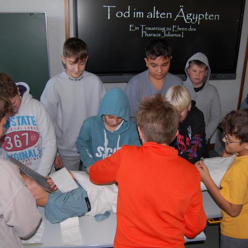 Schüler wickeln "Pharao" ein