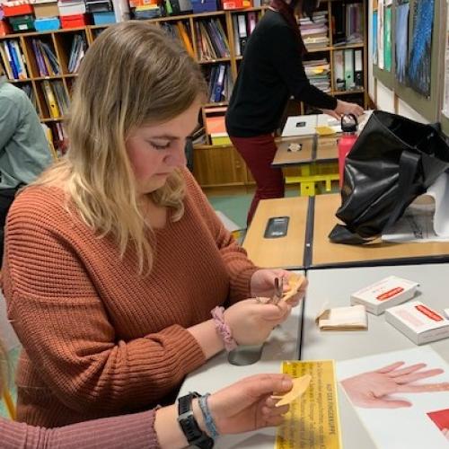 Lehrerin schneidet Pflaster nach angegebener Vorlage.