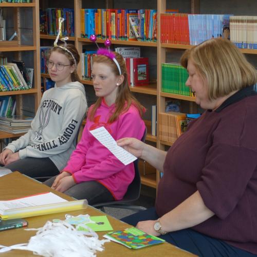 Lehrerin mit Schülerinnen in der Bücherei