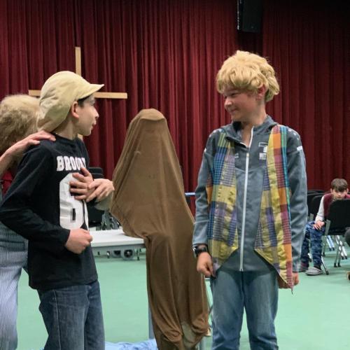 Schüler:innen als Schauspieler:innen auf der Bühne in der Aula