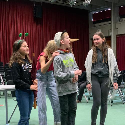 Schüler:innen als Schauspieler:innen auf der Bühne in der Aula