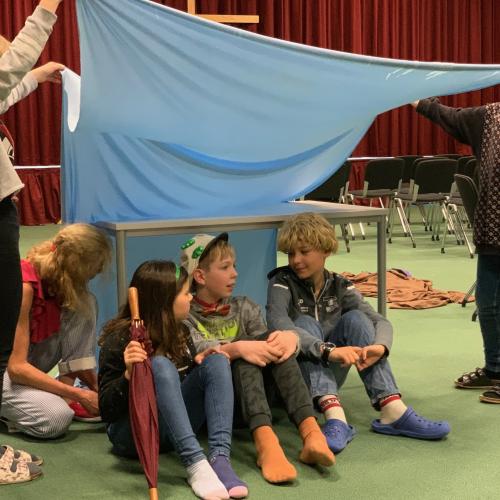Schüler:innen als Schauspieler:innen auf der Bühne in der Aula