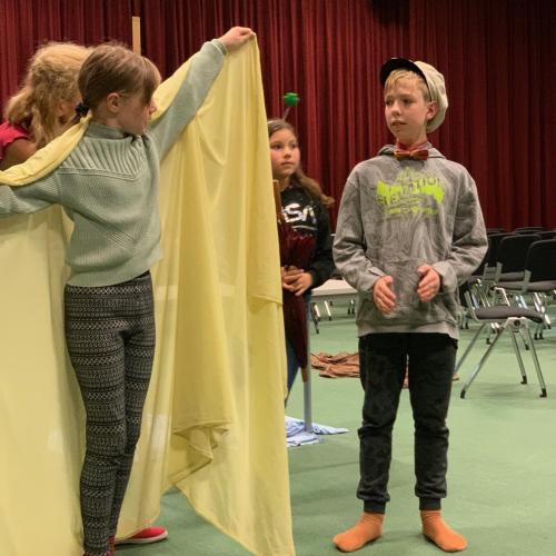 Schüler:innen als Schauspieler:innen auf der Bühne in der Aula