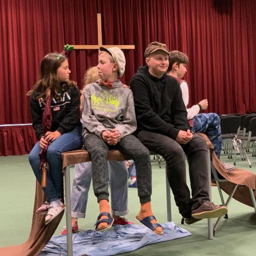 Schüler:innen als Schauspieler:innen auf der Bühne in der Aula