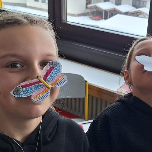 Selbstgebastelter Schmetterling wird im Schwerpunkt auf Nasen balanciert.