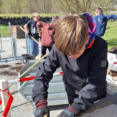 Schüler:innen beim Vorbereiten und Befüllen der Hochbeete