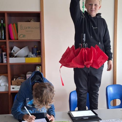 Schüler wiegt Regenschirm ab