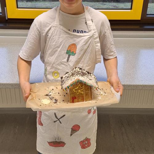 Schüler präsentiert sein Lebkuchenhaus