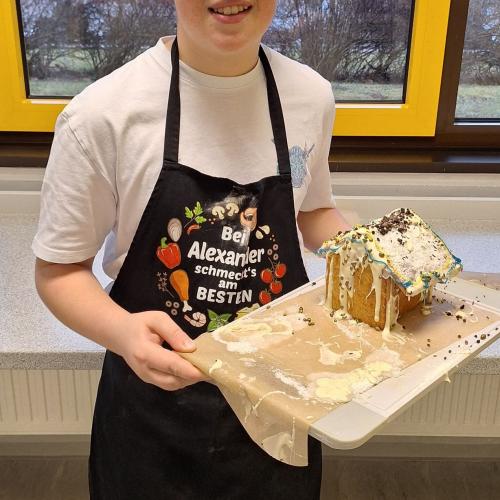 Schüler präsentiert sein Lebkuchenhaus