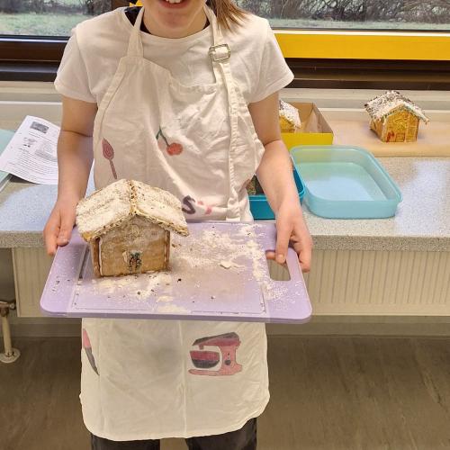 Schülerin präsentiert ihr Lebkuchenhaus