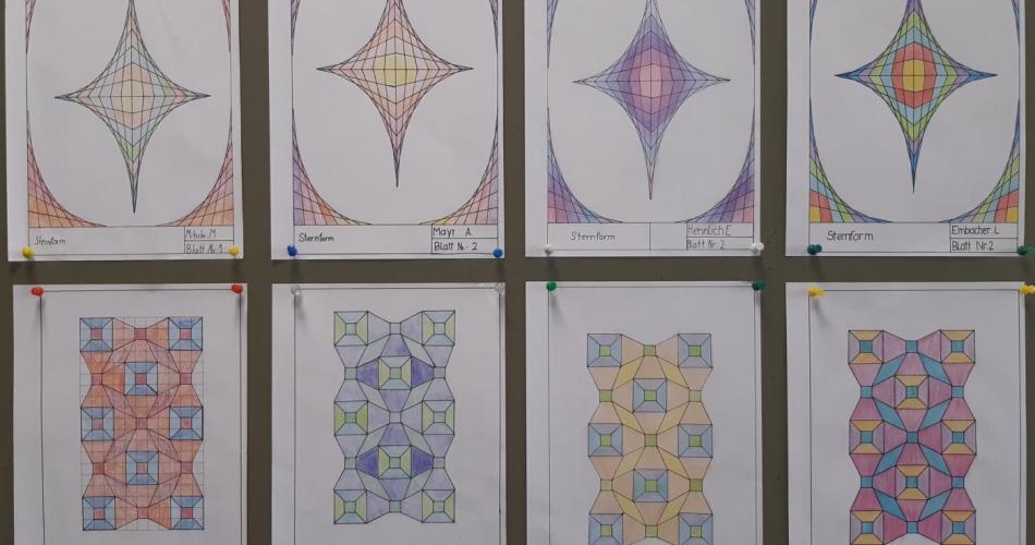 Eine Sammlung geometrischer Zeichnungen an einer Pinnwand