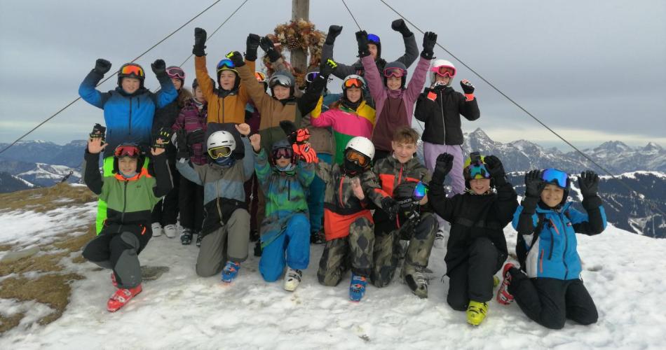 Schülerinnen und Schüler vor einem Gipfelkreuz bei der Skiwoche
