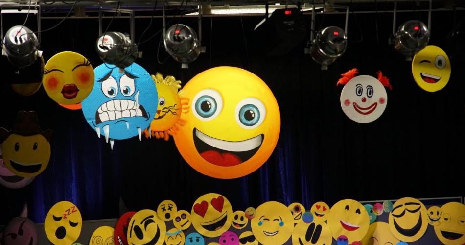 Bühne mit vielen verschiedenen Emoji Smiley ist zu sehen. Schwarzer Hintergrund